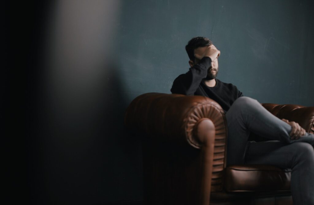 man holding is head upset about his sex addiction