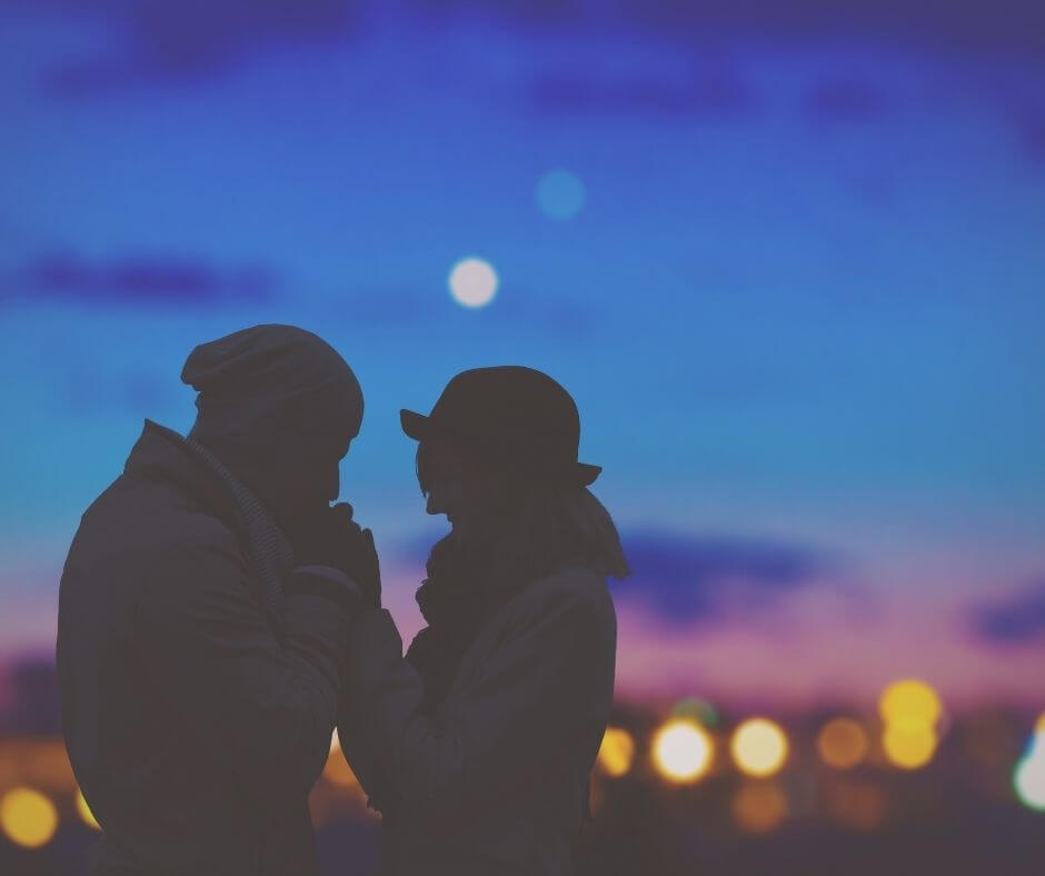 A couple in front of city lights