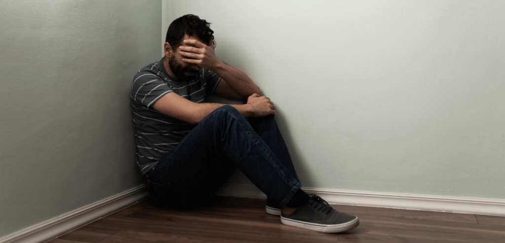 Adult men crying and having an emotional breakdown in the floor, corner of the wall