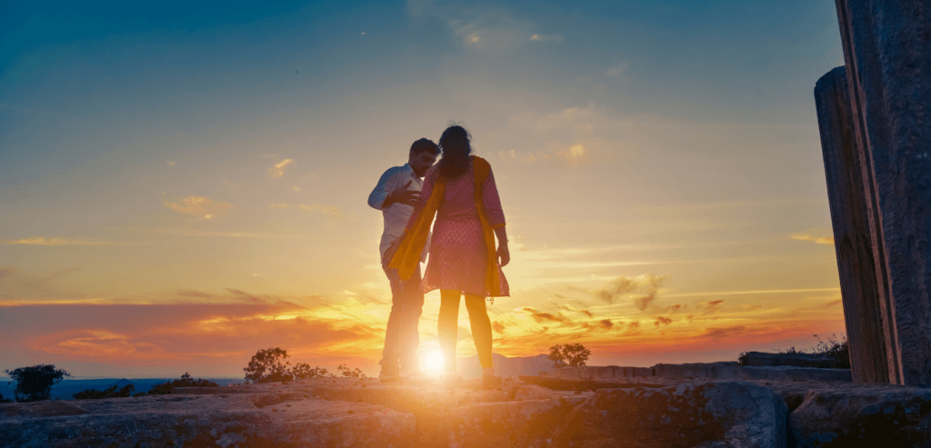 Interracial couple standing and watching sunset trying to have a conversation