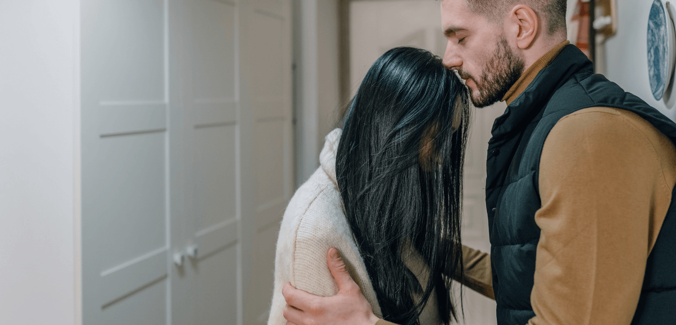 Man hugging partner kissing head looking like they have problem