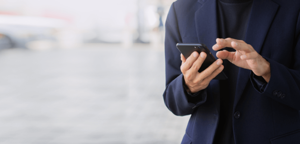 Focus shot of man wearing suit using mobile phone at public place
