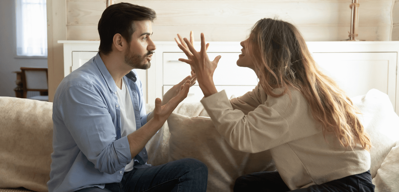 Couple on sofa arguing having heated argument