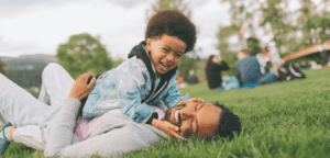 Father and son laughing and bonding while playing at the park.