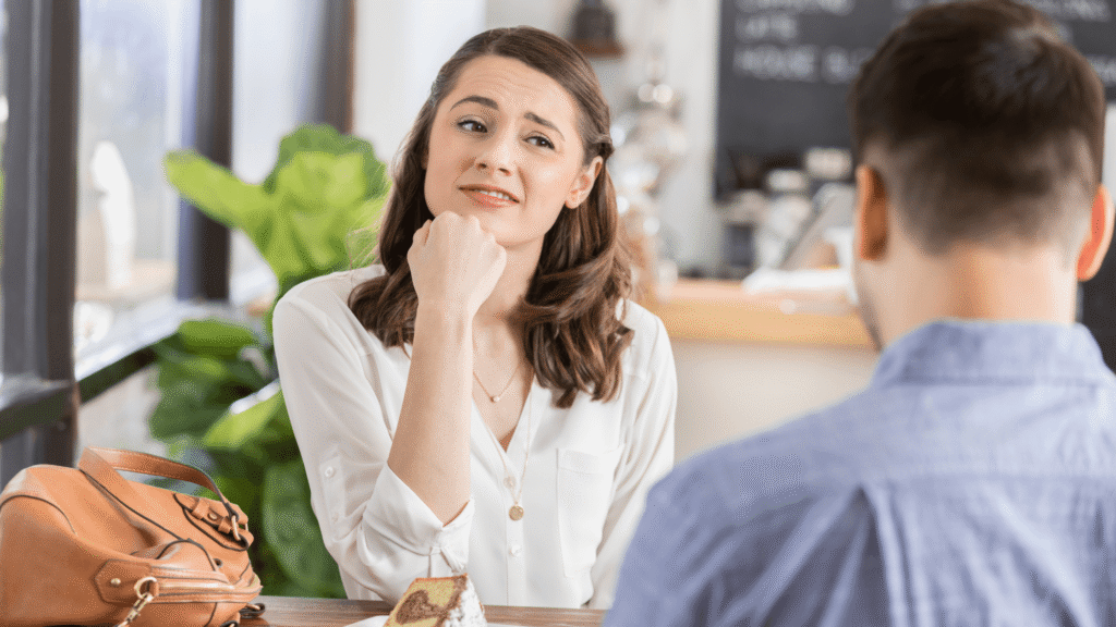 Couple seated, woman with hand against cheek listening closely