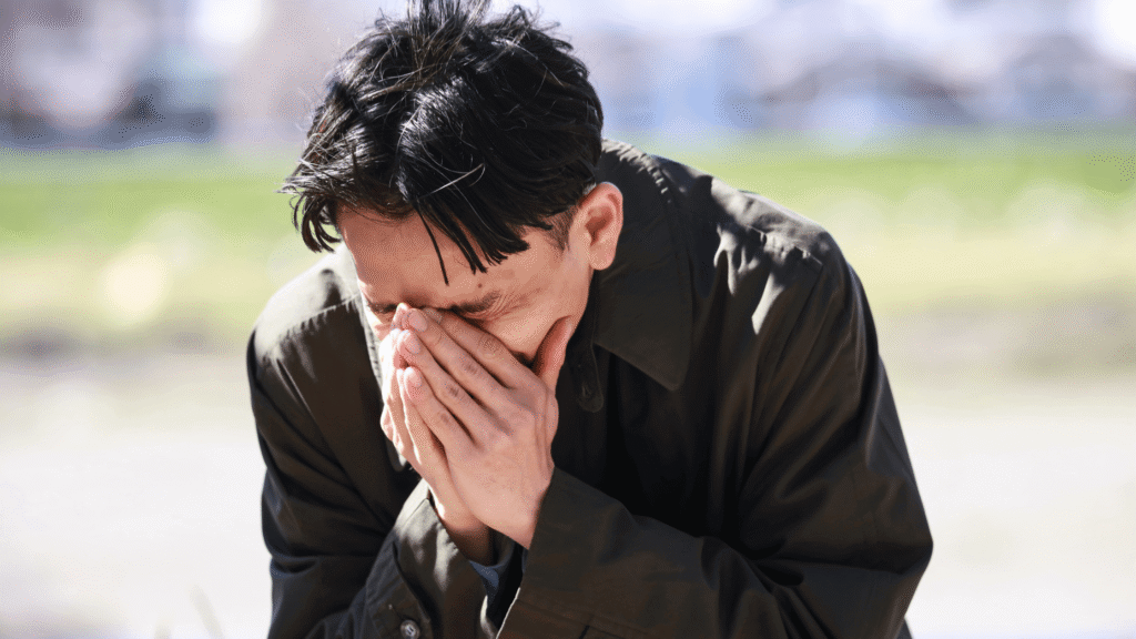 Weeping man on his knees in an open field