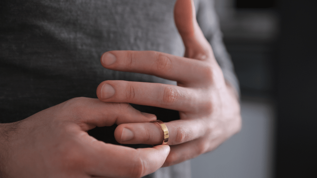 Close-up of a man's hand removing a wedding ring
