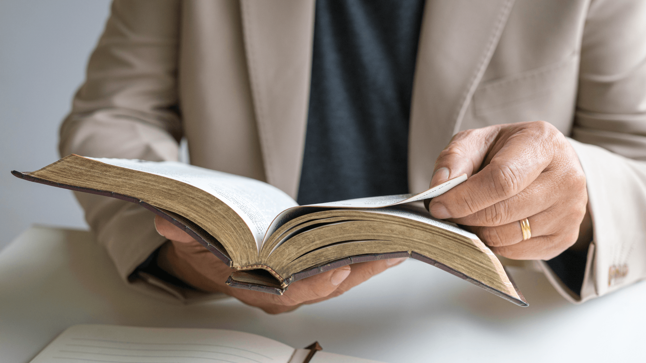 Focus shot of a person sitting down with the Bible open.