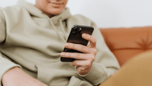 Focused shot of a man in a jacket using a phone.