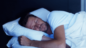Man sleeping alone in bedroom, appearing comfortable and in deep sleep