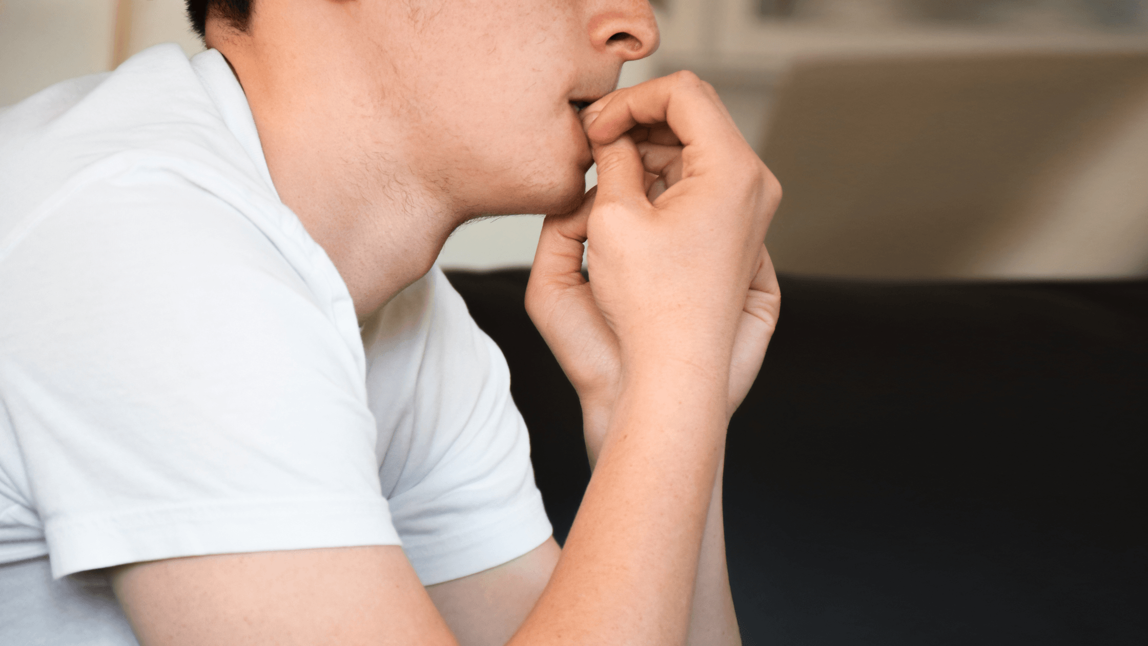 Close-up of a man with an anxious expression, biting his nails