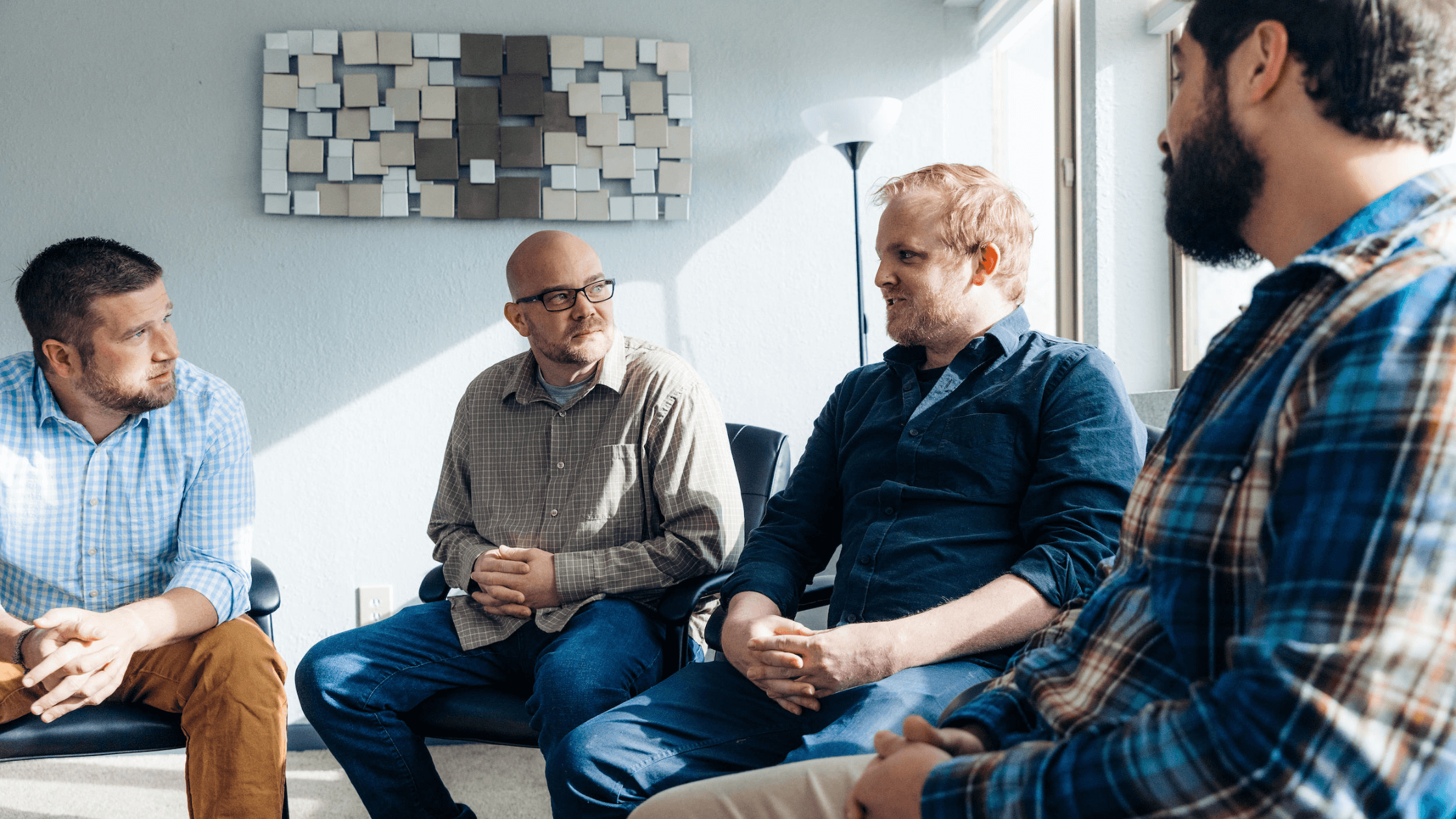 One man speaking during a group discussion while others listen in a circle